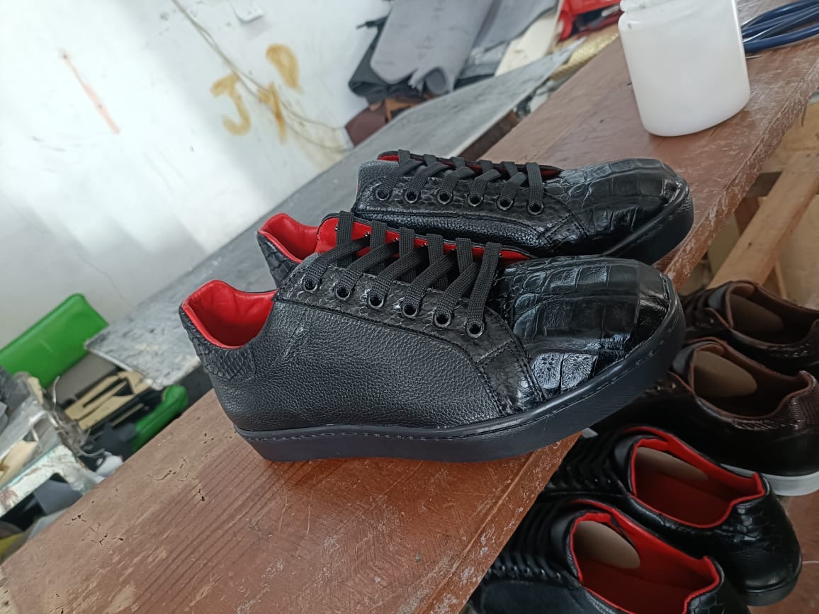 Tenis negro con interior rojo en taller